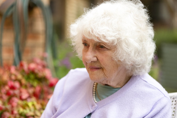 肖像美丽的妇女坐在花园，侧视图，背景与复制空间图片下载