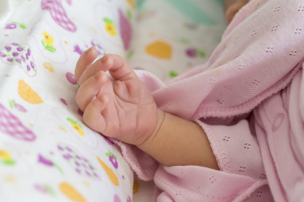在小床上睡觉的新生儿的手图片下载