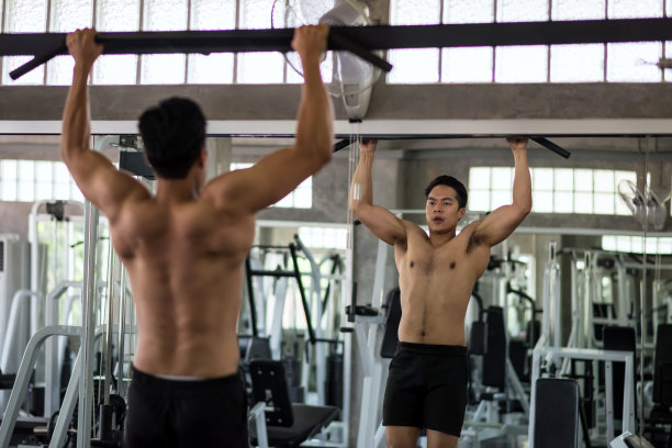 肌肉发达的亚洲男人在健身房拉杆图片下载