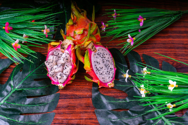 火龙果或火龙果带切片，孤立于观赏叶背景上，食用异域热带营养食品图片下载