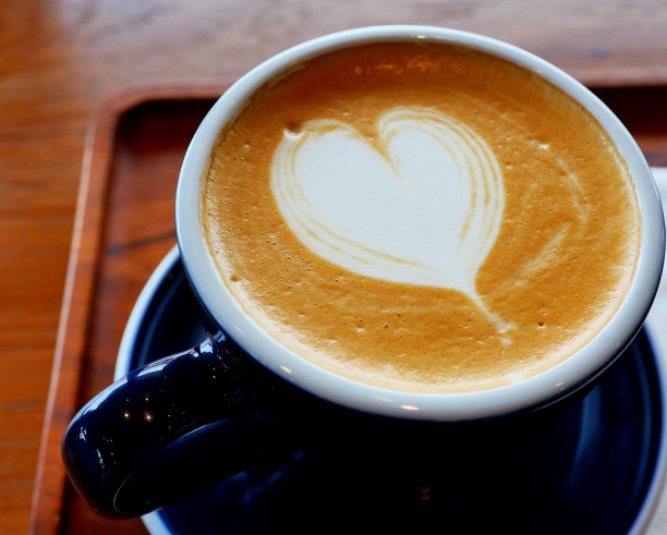 木桌上白色杯子里的拿铁咖啡图片下载