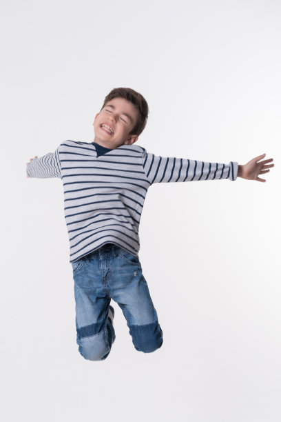 快乐的男孩在白布上跳图片下载