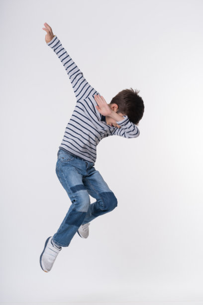 快乐的男孩在白布上跳图片下载