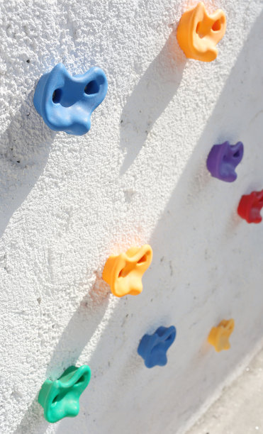 攀爬在白色的混凝土墙上。图片下载