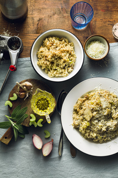 经典的意大利调味饭配蘑菇，木桌配蓝色亚麻布桌布。红酒。瓶子和眼镜。前照片图片下载