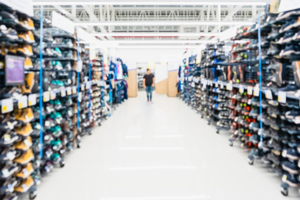 抽象模糊的运动鞋货架上的运动鞋商店背景。模糊的城市购物的人在市场运动鞋商店。图片下载