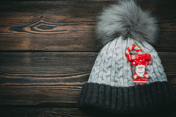 木制背景上编织的帽子圣诞树玩具图片下载