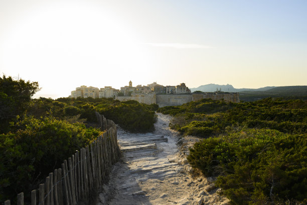 令人惊叹的日落照亮了一条通往美丽村庄博尼法乔的山路。索,法国科西嘉岛。图片下载