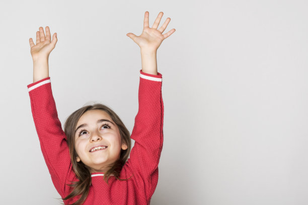 年轻的女孩举起手微笑着图片下载