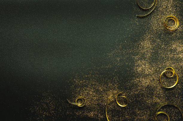 黑色背景上的金色闪光和缎带。节日的概念。——图片图片下载