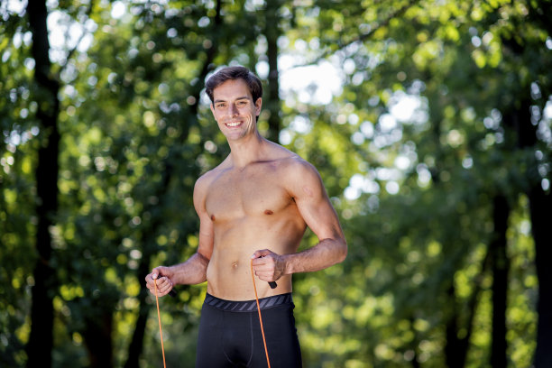 年轻人在大自然中练习跳绳图片下载