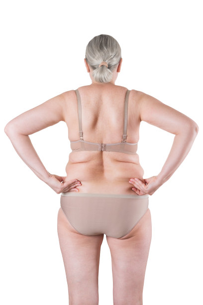 老胖女人孤立在白色的背景，超重的背部与皱褶的皮肤图片下载