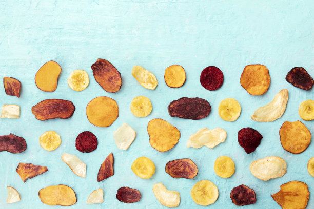 干果和蔬菜片，从顶部拍摄的蓝色背景和文字的地方。健康素食零食，有机食品平铺图案与复制空间图片下载