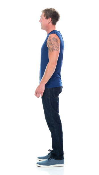 全身/侧视图/侧面视图/一人一男子/ 20-29岁的成年人英俊的人白人男性/年轻男子无袖站着穿着背心/牛仔裤/裤子/帆布鞋谁是微笑/快乐/愉快/大笑图片下载