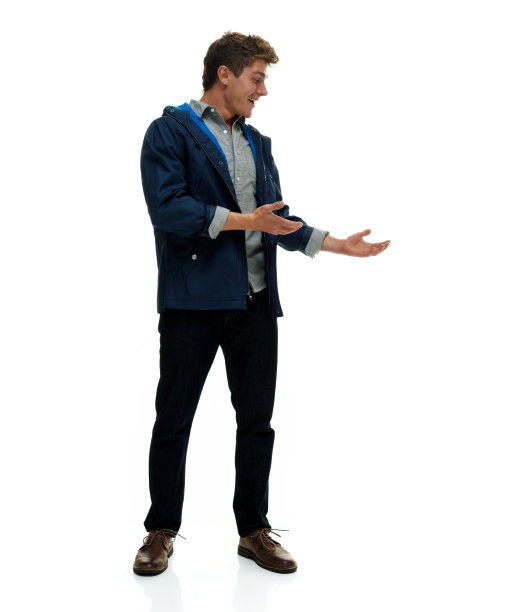 全长/一人/一人/侧视/侧视/看向一边/斜视20-29岁的成年人英俊的人棕色头发/短发白人男性/年轻男性主持人站在白色背景前图片下载