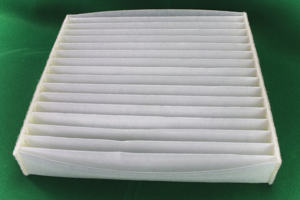 绿色背景的汽车空气滤清器。汽车滤镜关闭。图片下载