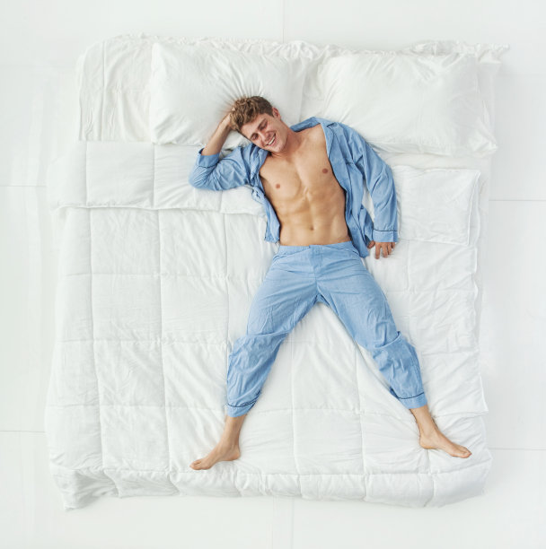 全长/一人/一人/直接上方视图/正面视图/看相机/看20-29岁的成年人英俊的人棕色头发/短发高加索男性/年轻男子在白色背景的卧室图片下载