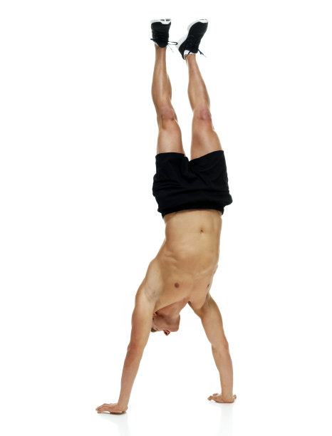 全身/一人/一人/正面20-29岁的成年人英俊的人棕色头发/短发高加索男性/年轻男子跑步/锻炼/慢跑/倒立/敏捷/在白色背景前倒立图片下载