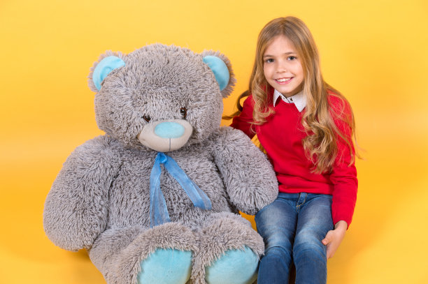 孩子带着灰色的软玩具微笑图片下载