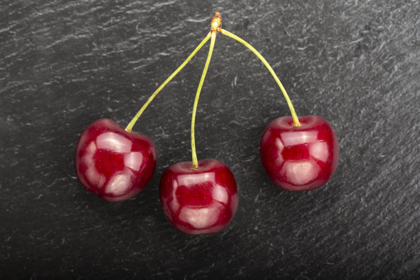黑色背景上的甜樱桃。简约水果背景。图片下载
