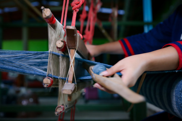 棉花编织。妇女在手工织布机上以传统的方式手工编织棉花。泰国传统的棉花。有选择性的重点。图片下载