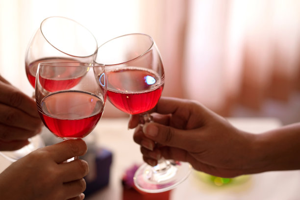 在聚会上，朋友们手握红酒庆祝成功。年轻人在派对上举杯，工作后喝酒，努力放松和享受。庆祝概念，干杯!图片下载