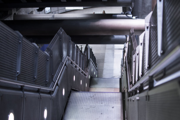 地铁站的工业楼梯，顶部是灰色的管道图片下载