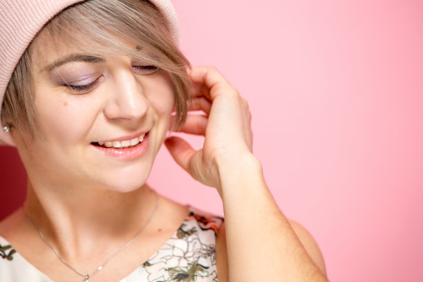 年轻漂亮的女人戴着温暖的针织帽图片下载