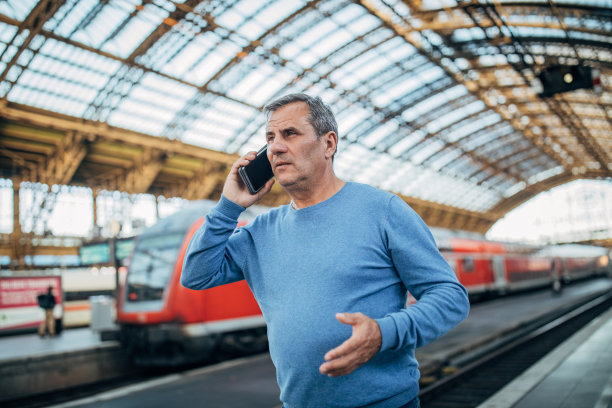 一个成熟的男人在火车站打电话图片下载