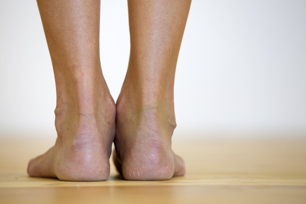 女人光着脚在地板上。腿部护理和皮肤护理理念。图片下载