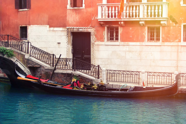 威尼斯老房子里的贡多拉。运河附近有座红房子，停泊着一艘船。图片下载