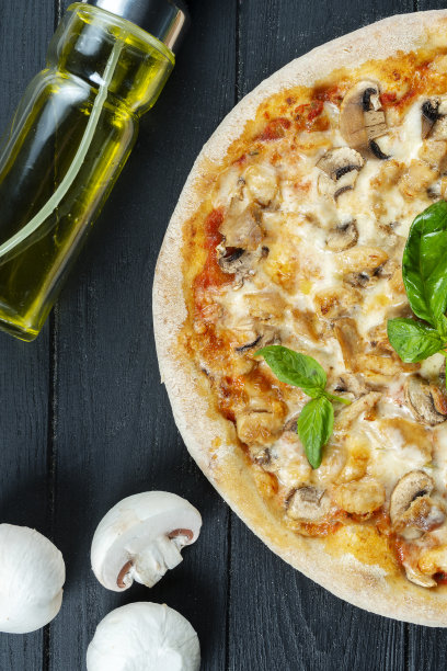 自制的新鲜披萨与烟熏鸡肉，蘑菇，罗勒和白酱在一个黑色的木头复制空间。俯视图食物照片。平的。意大利菜。图片下载