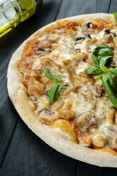 自制的新鲜披萨与烟熏鸡肉，蘑菇，罗勒和白酱在一个黑色的木头复制空间。俯视图食物照片。平的。意大利菜。图片下载