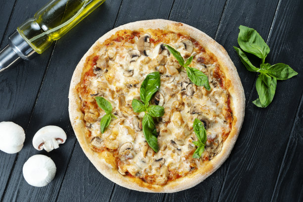 自制的新鲜披萨与烟熏鸡肉，蘑菇，罗勒和白酱在一个黑色的木头复制空间。俯视图食物照片。平的。意大利菜。图片下载