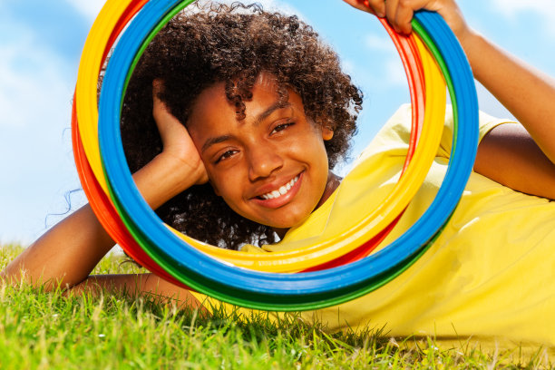 女孩的肖像透过草地上的彩色圈看图片下载