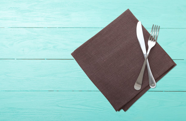 木桌上放着餐具和餐巾。设计餐巾的模型。餐巾俯视图广场。图片下载