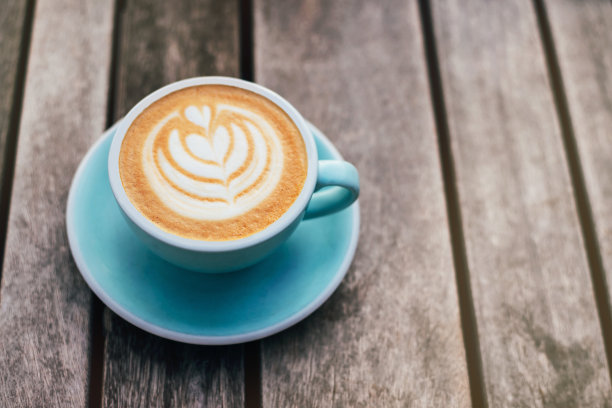 新鲜风味的咖啡艺术在木制背景上。图片下载