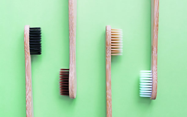 竹制牙刷搭配时尚的绿色背景。环保产品。生态、零浪费和健康理念。平的。文本。生物可降解材料图片下载