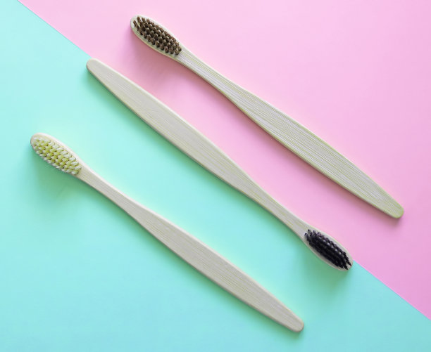 竹子牙刷的两种颜色的背景，时髦的蓝色和粉红色。环保产品。生态、零浪费和健康理念。平的。文本。生物可降解材料图片下载