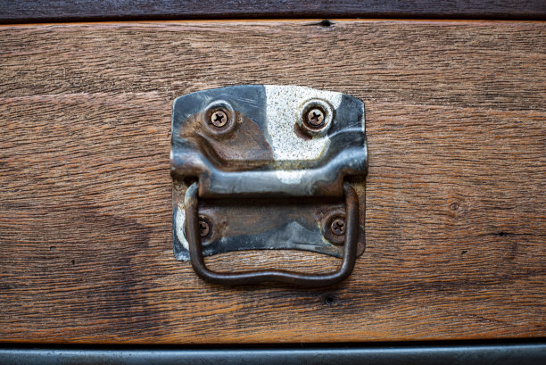 一个装在深棕色木抽屉上的老式把手图片下载