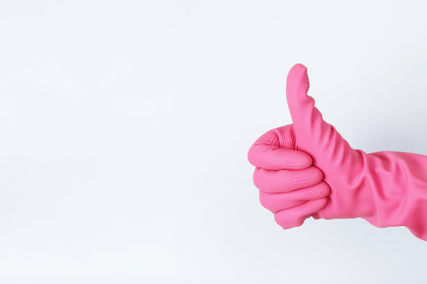 戴粉色橡胶手套的女人竖起大拇指，浅色背景图片下载