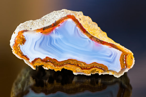 宝石的细节。抛光玛瑙横截面与美丽的反射在黑暗闪亮的背景。可收集的物品图片下载