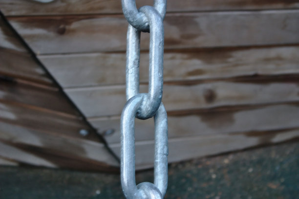 一个金属链的链环在一个木制的设计背景上图片下载