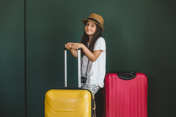 年轻的女孩穿着节日的衣服拉着手提箱图片下载