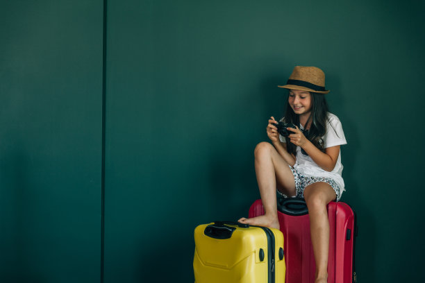 年轻的女孩穿着节日的衣服拉着手提箱图片下载