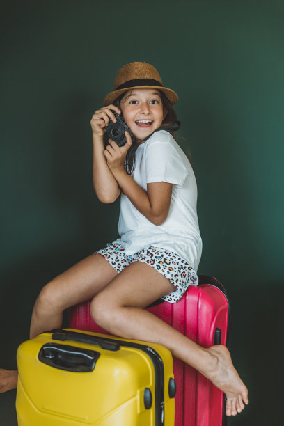 年轻的女孩穿着节日的衣服拉着手提箱图片下载
