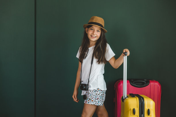 年轻的女孩穿着节日的衣服拉着手提箱图片下载