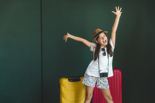 年轻的女孩穿着节日的衣服拉着手提箱图片下载