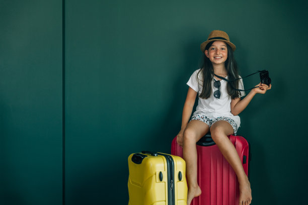年轻的女孩穿着节日的衣服拉着手提箱图片下载
