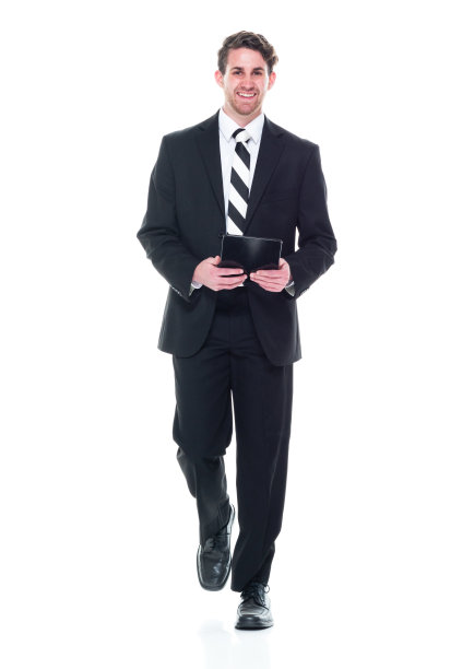 正面视图/看相机/全长/一个20-29岁的成年人英俊的人白种年轻男子/男性经理/商人/商人走在白色背景穿着西装和使用数字平板电脑图片下载